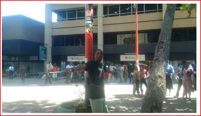 PICTURE: Pastor Patrick Mugadza chains himself in First Street Harare over Mugabe, Zanu PF rule