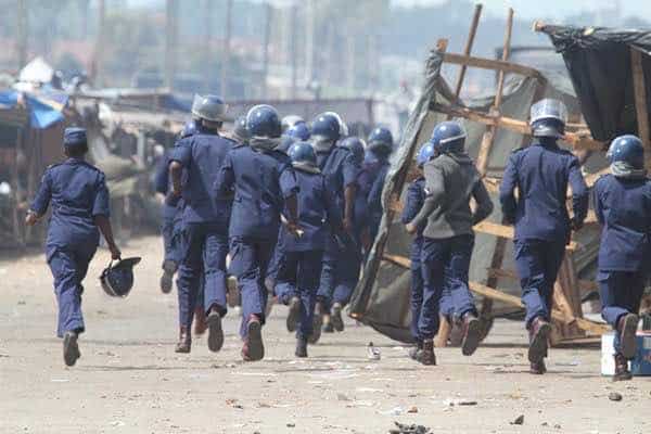 Armed Zimbabwe Republic Police officers shoot fleeing vendor