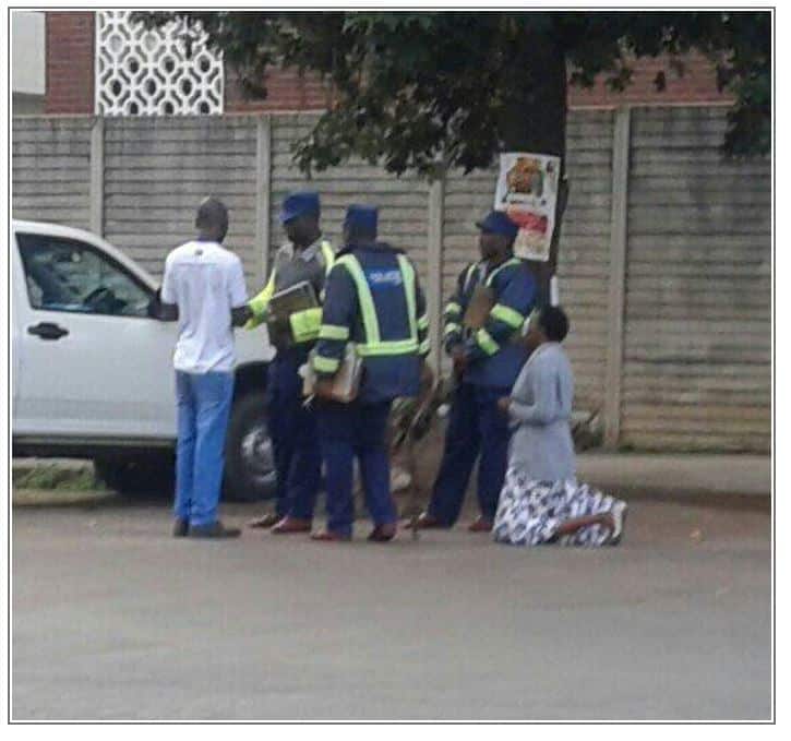 Woman kneels to evade police fine..Picture