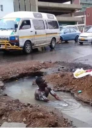 PICTURE: Man bathes  in Harare’s biggest pothole